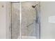 The fully tiled shower includes glass door, grab bar and convenient storage shelves at 553 Lake Gaston Dr, Fuquay Varina, NC 27526