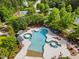 Aerial view showcases the pool, tennis courts, and surrounding greenery at 575 Tomkins Loop, Cary, NC 27519