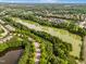 A serene aerial view of homes nestled around a tranquil lake and lush greenery, showcasing community living at 575 Tomkins Loop, Cary, NC 27519