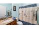 Bright bathroom featuring granite countertop vanity and coordinated floral shower curtain at 575 Tomkins Loop, Cary, NC 27519