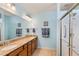 Well-lit bathroom featuring a double vanity with granite countertops and a glass-enclosed shower at 575 Tomkins Loop, Cary, NC 27519