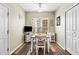Bright dining room with hardwood floors, ceiling fan, and a large window for natural light at 575 Tomkins Loop, Cary, NC 27519