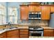 This kitchen features granite countertops, stainless steel appliances, and wooden cabinetry at 575 Tomkins Loop, Cary, NC 27519