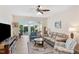 Bright living room featuring hardwood floors, comfortable seating, and an open view to a backyard patio at 575 Tomkins Loop, Cary, NC 27519