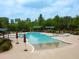 Large community swimming pool with hot tub, lounge chairs, umbrellas, and mature trees on a bright day at 575 Tomkins Loop, Cary, NC 27519