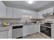 Well-lit kitchen with stainless steel appliances, white cabinets, and granite countertops at 5905 Westcreek Pl, Raleigh, NC 27606