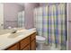 Standard bathroom with wallpaper, toilet, and a sink with wooden cabinets at 6 Parsons Chase Ln, Durham, NC 27713