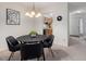 Elegant dining area featuring a modern light fixture and a view into the kitchen and hallway at 6 Parsons Chase Ln, Durham, NC 27713