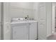 The laundry room has a standard washer and dryer and overhead storage at 6 Parsons Chase Ln, Durham, NC 27713