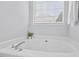 Bathroom features a soaking tub under a window at 611 Quartz Dr, Durham, NC 27703