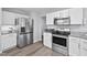 Well-lit kitchen features stainless steel appliances, white cabinets, and gray countertops at 611 Quartz Dr, Durham, NC 27703
