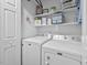 Spacious laundry room with washer, dryer, shelving, and decor at 611 Quartz Dr, Durham, NC 27703