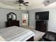 The primary bedroom has a tray ceiling, ceiling fan, mounted TV and a view of a second bedroom at 6225 Acorn Ridge Trl, Hillsborough, NC 27278