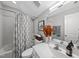 A modern bathroom featuring a shower-tub combination and sleek vanity with a decorative orange bouquet of flowers at 6300 Pleasant Pines Dr # 101, Raleigh, NC 27613