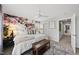 Bright bedroom featuring a floral accent wall, with a ceiling fan, neutral colors, and soft carpet at 6300 Pleasant Pines Dr # 101, Raleigh, NC 27613