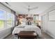 Bright bedroom with a floral accent wall, ceiling fan, and natural light from the large windows at 6300 Pleasant Pines Dr # 101, Raleigh, NC 27613