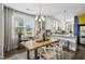 Bright dining area featuring a wood table, stylish chairs, and an open view to the modern kitchen at 6300 Pleasant Pines Dr # 101, Raleigh, NC 27613
