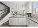 Open-concept kitchen featuring granite counters, white cabinets, and seamless flow to living areas at 6300 Pleasant Pines Dr # 101, Raleigh, NC 27613