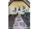 Exterior backyard entrance featuring stepping stones and landscaping around the home at 650 Ganyard Farm Way # 32, Durham, NC 27703