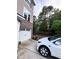 Side view of a home with a white Tesla parked in the driveway, surrounded by trees at 651 Berry Chase Way, Cary, NC 27519