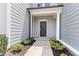Inviting front entry with a black door, gray siding, and manicured landscaping at 706 Ambrose Hill Lane Ln, Wendell, NC 27591