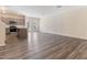 Open-concept living area with kitchen and stainless steel appliances view and gray wood-look flooring at 706 Ambrose Hill Lane Ln, Wendell, NC 27591