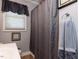 This bathroom features a window with gray valance and curtain and gray towels on a chrome rack at 712 E Horne St, Clayton, NC 27520