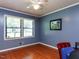 Bright bedroom with hardwood floors, ceiling fan, double windows, and neutral blue wall color at 712 E Horne St, Clayton, NC 27520