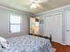Bedroom with hardwood floors, bed with patterned bedding, and closet at 712 E Horne St, Clayton, NC 27520