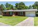Charming one-story brick home featuring a well-manicured lawn, single car garage, and inviting front entrance at 712 E Horne St, Clayton, NC 27520