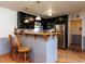 Kitchen with a bar, seating, dark cabinetry, stainless steel appliances and pendant lighting at 712 E Horne St, Clayton, NC 27520