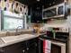 Efficient kitchen with black cabinetry, a white tile backsplash, stainless steel appliances, and modern fixtures at 712 E Horne St, Clayton, NC 27520