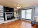 Cozy living room with hardwood floors, a fireplace with built-in shelving and a ceiling fan with lighting at 712 E Horne St, Clayton, NC 27520