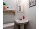 Powder room with pedestal sink, toilet, and decorative shelf at 712 E Horne St, Clayton, NC 27520