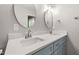Bathroom with double sinks, large mirrors, white quartz countertops, and modern fixtures at 716 Sandra St, Garner, NC 27529