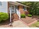 Charming brick home with blue shutters and brick steps leading to the front door at 716 Sandra St, Garner, NC 27529