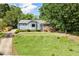 Quaint home featuring a lush front yard, a blend of brick and siding, and mature shade trees at 716 Sandra St, Garner, NC 27529