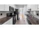 Bright kitchen featuring white cabinets, stainless steel appliances, stylish backsplash, and dark countertops at 716 Sandra St, Garner, NC 27529