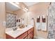 Bathroom with double sink vanity, ample lighting, and decorative shower curtain at 74 Fountain Dr, Clayton, NC 27520