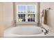 Bathtub beneath a large window in a bright bathroom at 74 Fountain Dr, Clayton, NC 27520