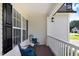 Relaxing covered front porch with dark wood flooring, seating, and stylish lighting fixtures at 74 Fountain Dr, Clayton, NC 27520