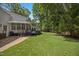 Lush backyard with green grass, an exterior of the house and mature trees at 7917 Rooksley Ct, Raleigh, NC 27615