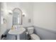 Clean bathroom features pedestal sink, silver mirror and updated lighting at 7917 Rooksley Ct, Raleigh, NC 27615