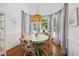 Bright breakfast nook featuring a round table, four chairs, and a large window with beautiful striped curtains at 7917 Rooksley Ct, Raleigh, NC 27615