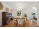 Bright dining room with hardwood floors, large window, and classic piano at 7917 Rooksley Ct, Raleigh, NC 27615