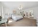 Bright main bedroom featuring carpet, white walls, large windows, seating area and en-suite bathroom at 7917 Rooksley Ct, Raleigh, NC 27615