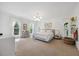 Spacious main bedroom with large windows, a seating area, carpet flooring and modern chandelier at 7917 Rooksley Ct, Raleigh, NC 27615