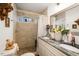 Bathroom with tile shower and dual vanity sinks, featuring granite countertops and decorative accents at 810 Grovemont Rd, Raleigh, NC 27603