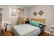 Comfortable bedroom featuring wood floors, a cozy bed, and ample natural light from the window at 810 Grovemont Rd, Raleigh, NC 27603