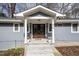 Inviting front entrance with double doors, a covered porch, and manicured landscaping at 810 Grovemont Rd, Raleigh, NC 27603